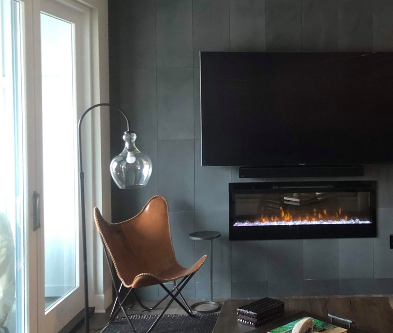 Stylish accent wall with flat panel television hanging above a modern recessed gas fireplace.